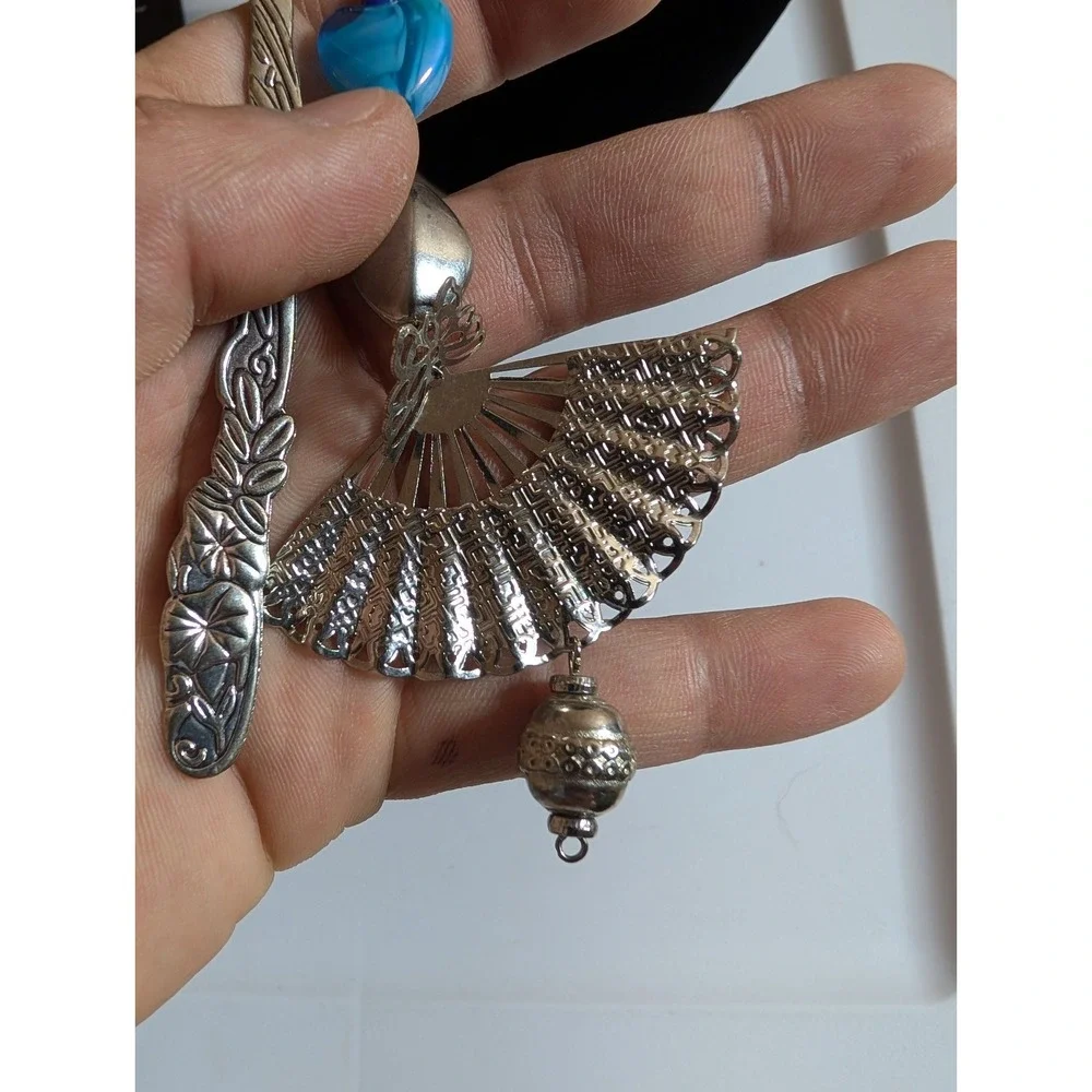 metal hook bookmark with a beaded charm featuring a fan pendant and a blue heart